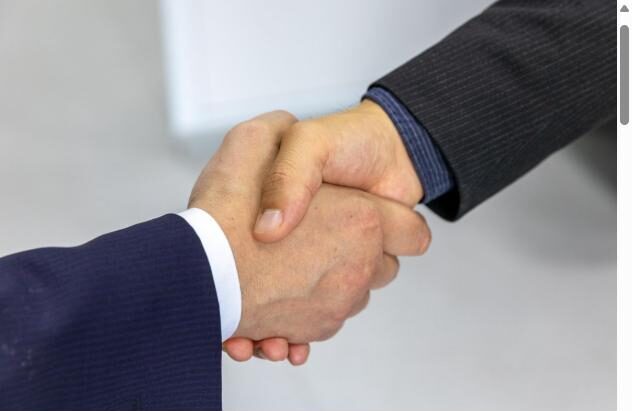 Two professionals shaking hands, representing City Healthcare Agency's flexible staffing partnerships
